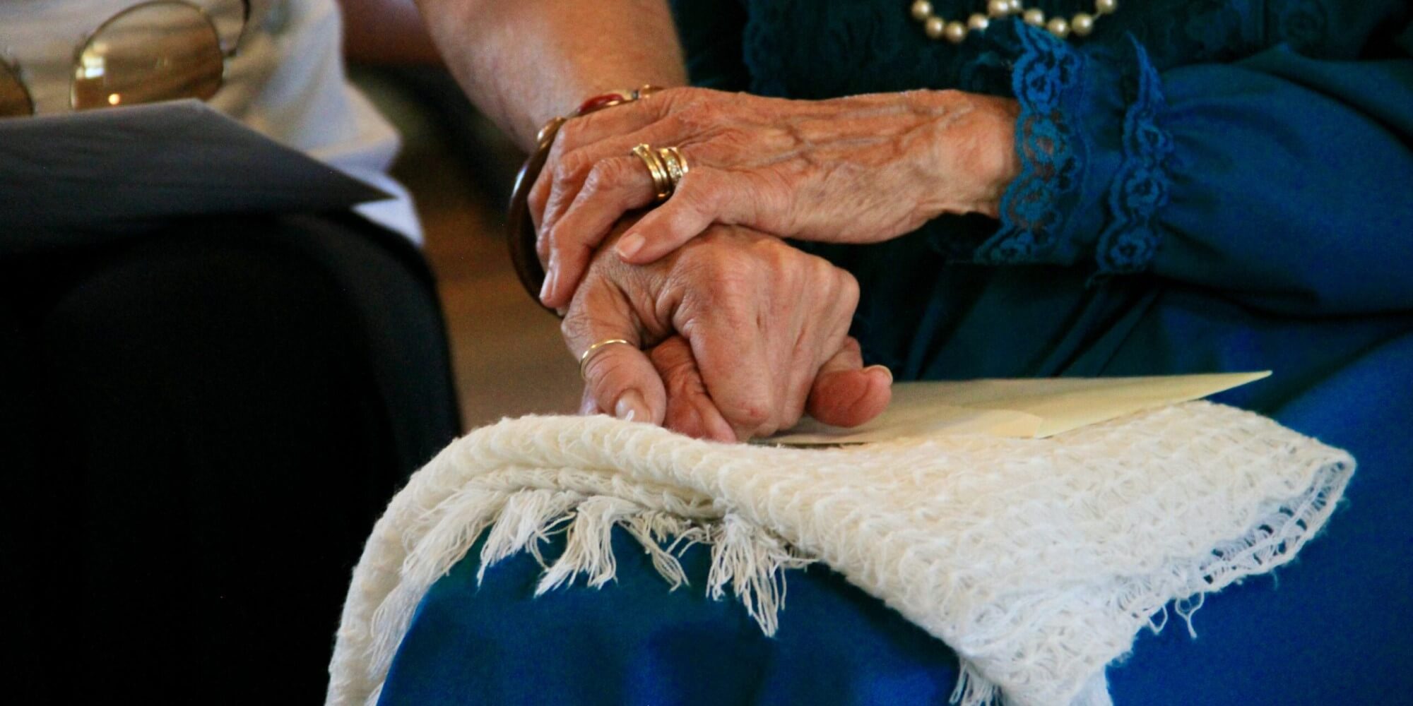 Senior and caregiver holding hands