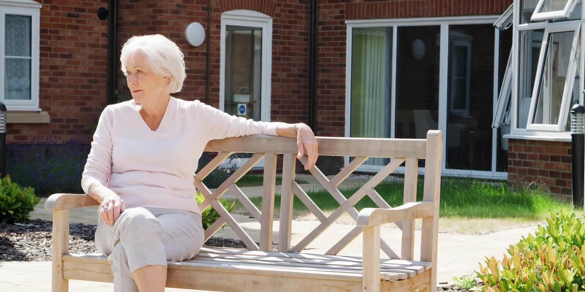 Senior resident sitting on a wooden bench