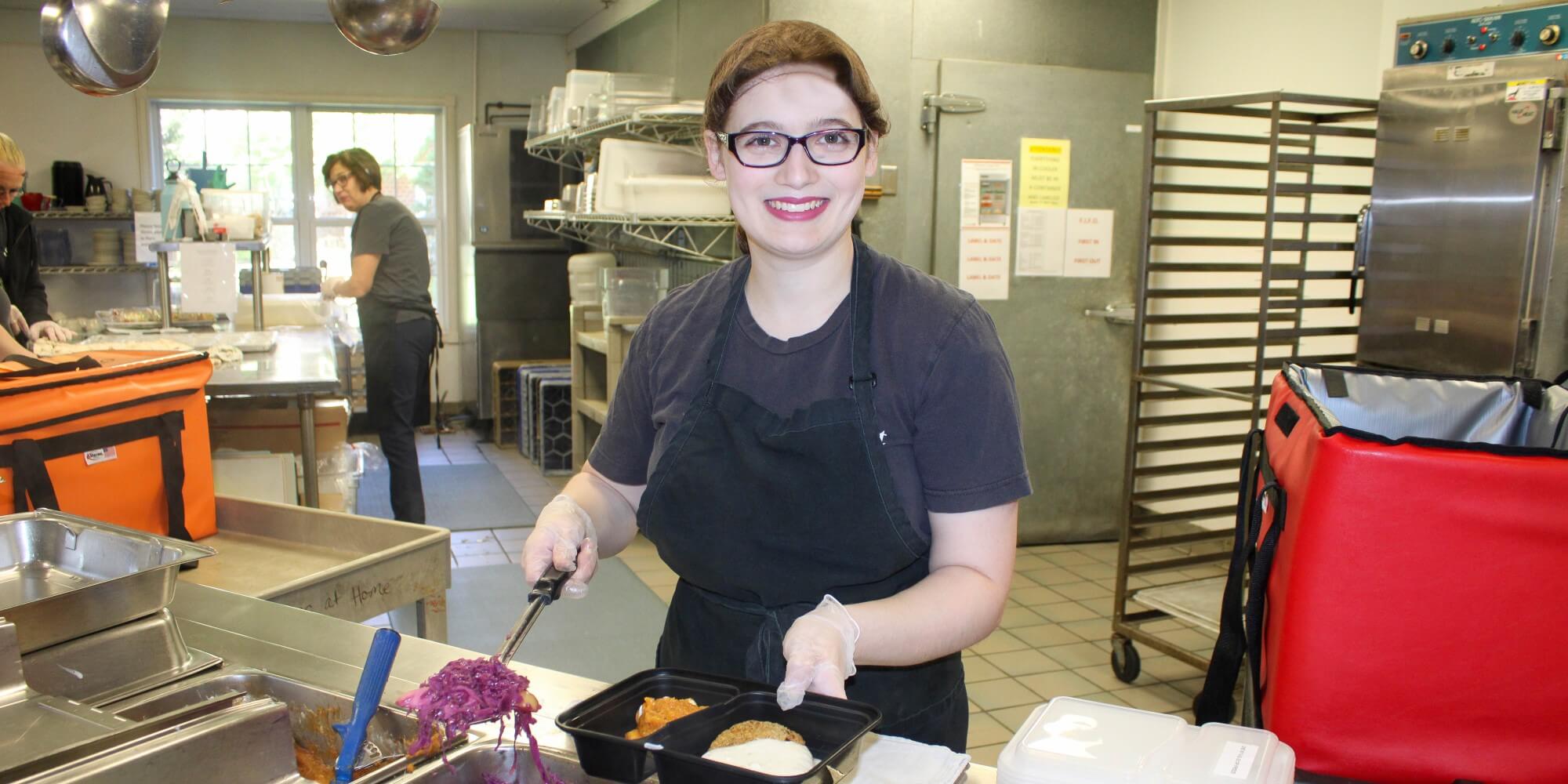 volunteer prepping meals for seniors