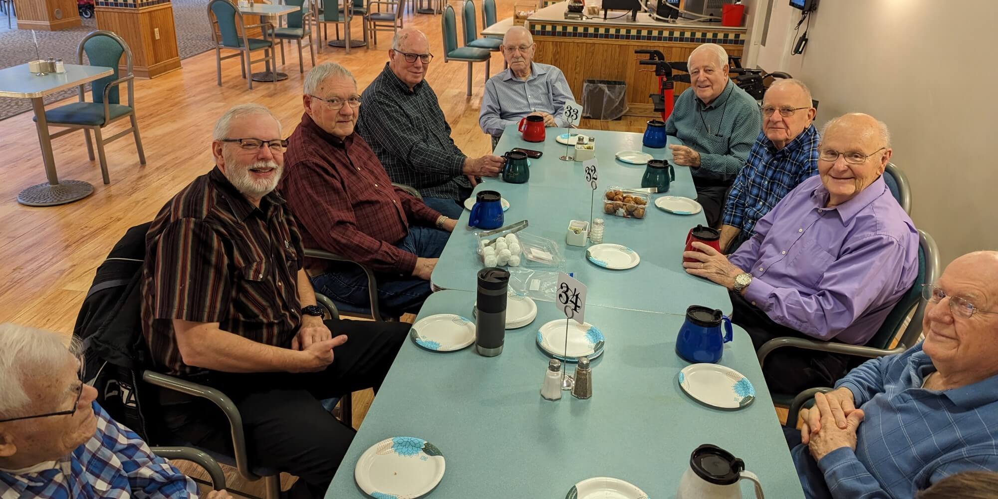 group of elderly men sitting around a table