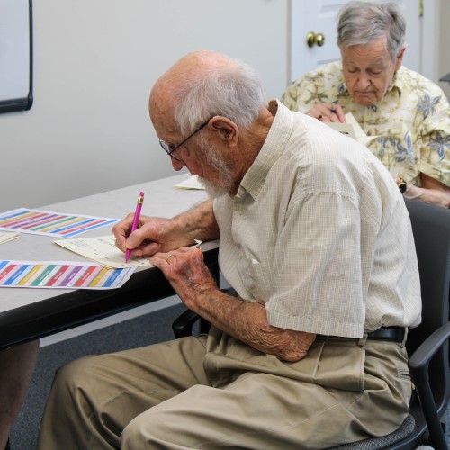 Older man writing on paper