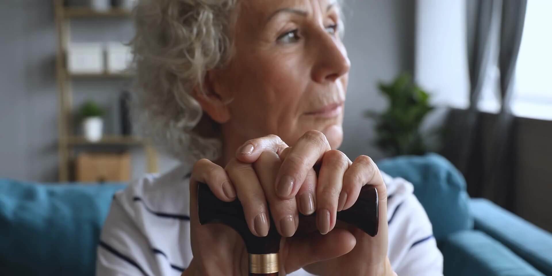 close up of older women staring out a window