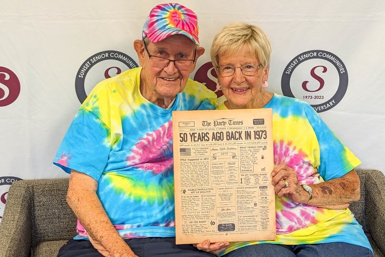 Manor & Villages residents holding a vintage newspaper from the 70s